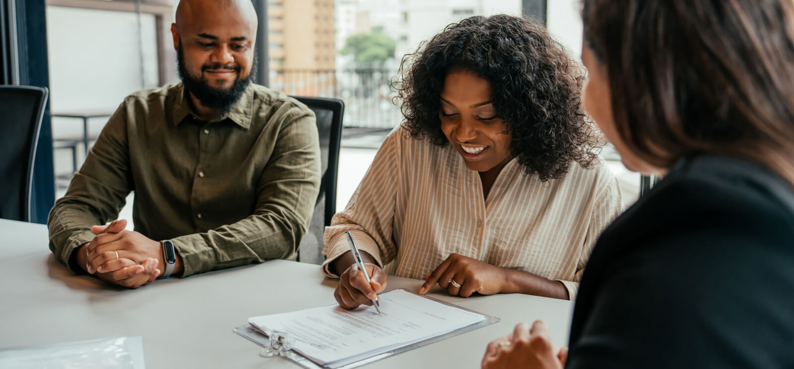 A man and woman signing paper documents